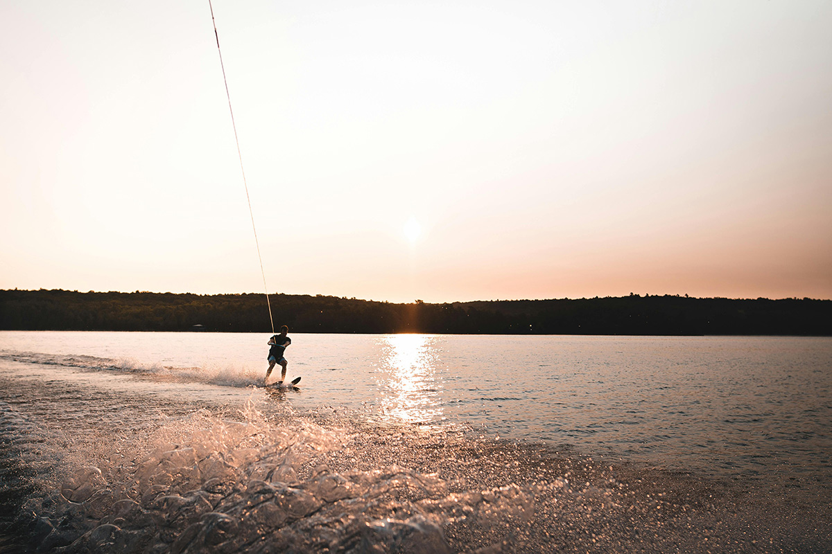 Image of someone water skiing on lake at sunset