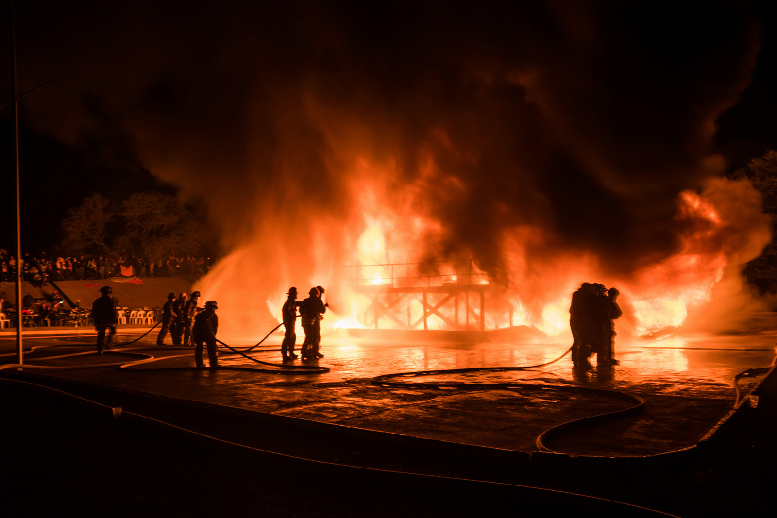 Firefighters battle a blaze at night.