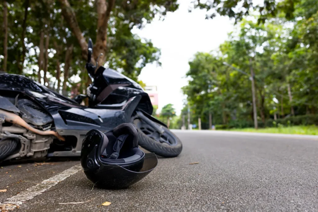 a motorcycle lying sideways with a helmet in front after an accident